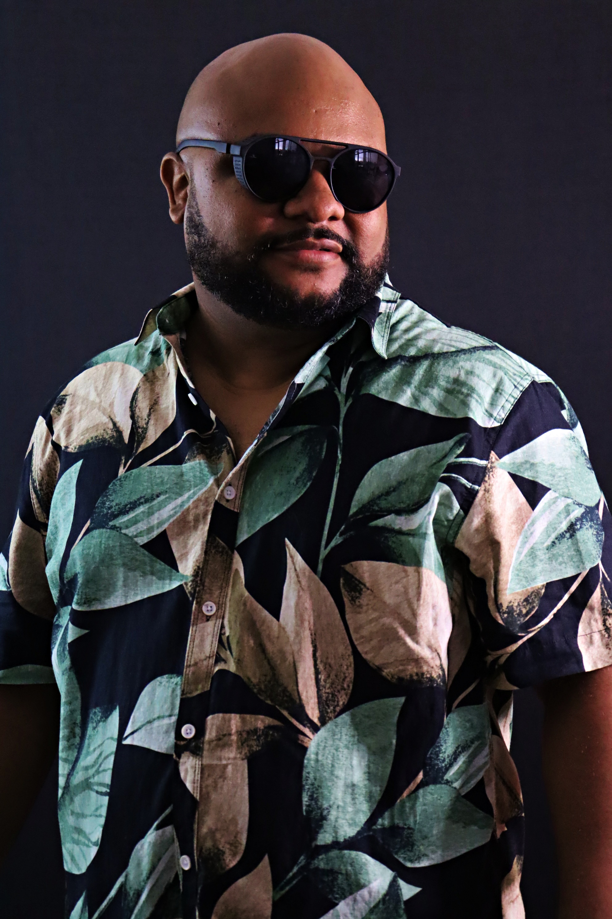 Retrato do cantor sertanejo Xandão com camisa estampada e óculos escuros