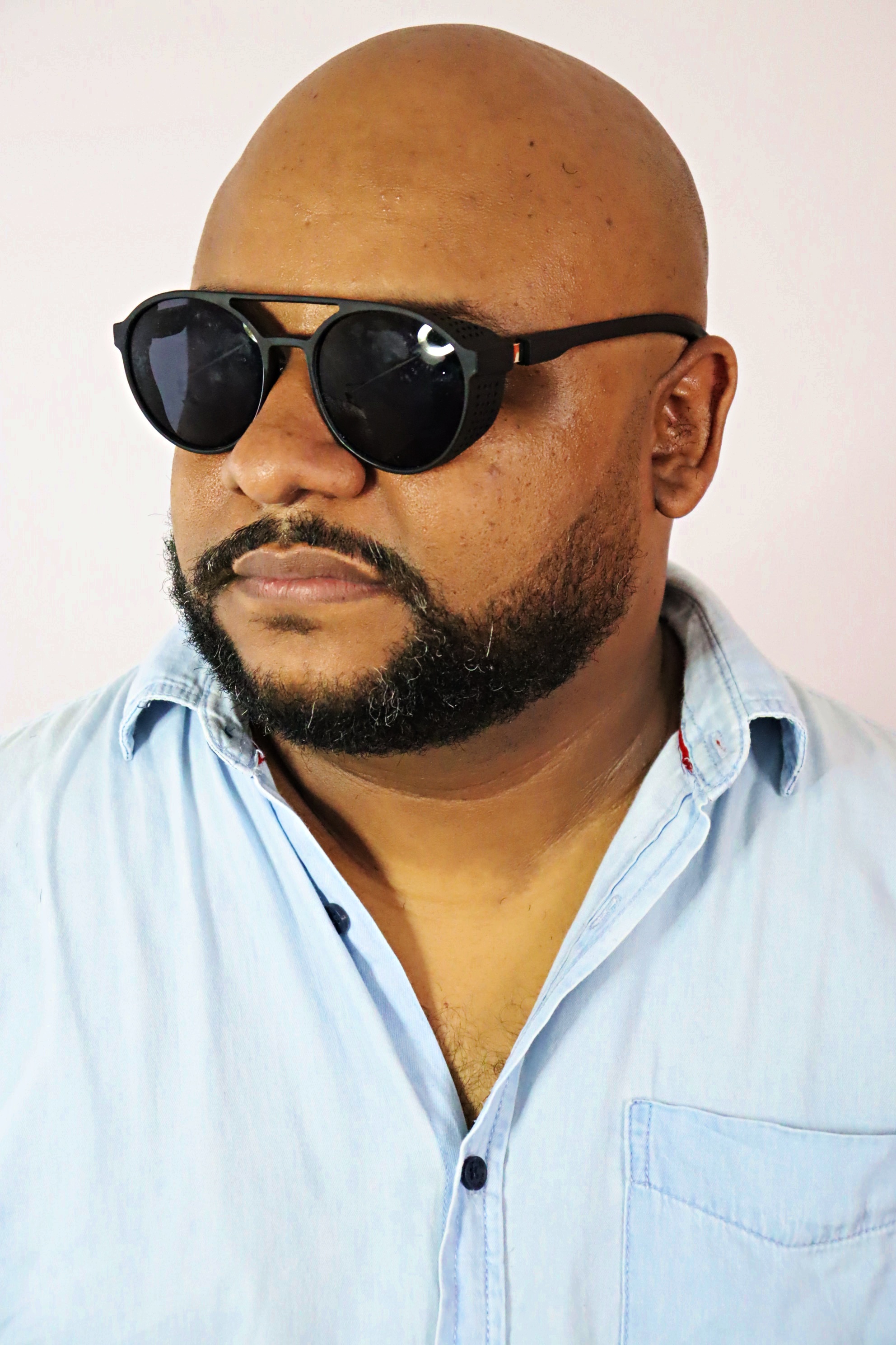 Retrato do cantor sertanejo Xandão com camisa jeans clara e óculos escuros